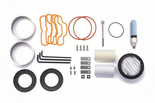 Components for a service kit are neatly arranged on a clean white table, ready for use.