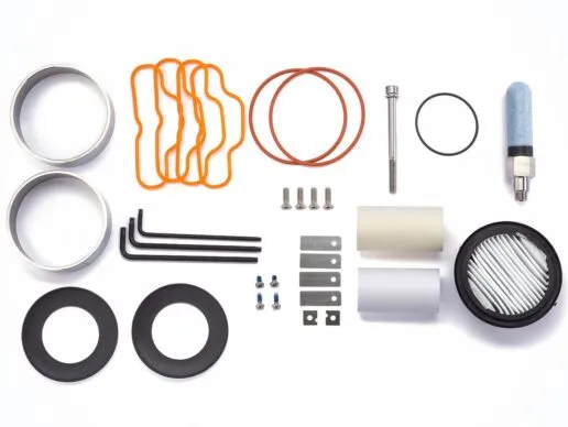 Components for a service kit are neatly arranged on a clean white table, ready for use.
