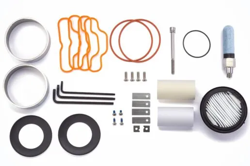 Components for a service kit are neatly arranged on a clean white table, ready for use.