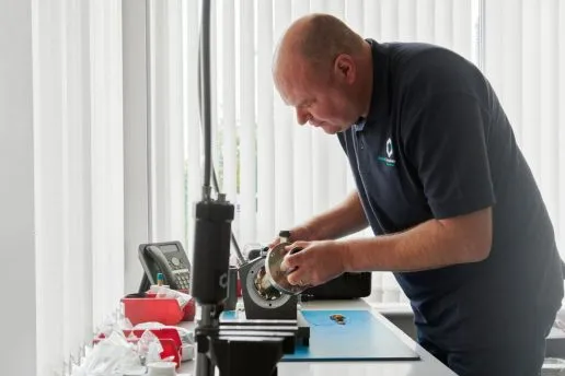 An Oxford Cryosystem's engineer services a single-stage Gifford McMahon cryocooler.