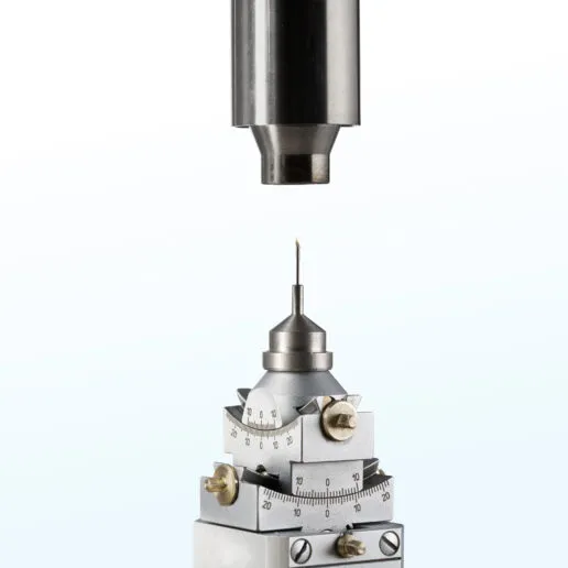 Close-up of a Cryostream nozzle precisely aligned above a MiTeGen sample pin and xHuber goniometer.